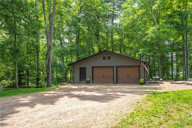 detached garage featuring a view of trees