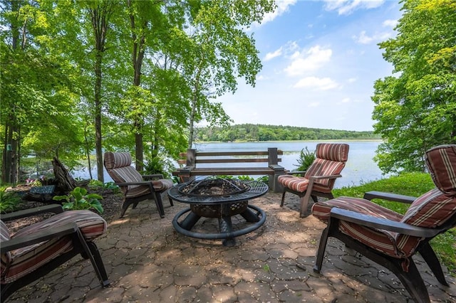 view of patio with an outdoor fire pit and a water view