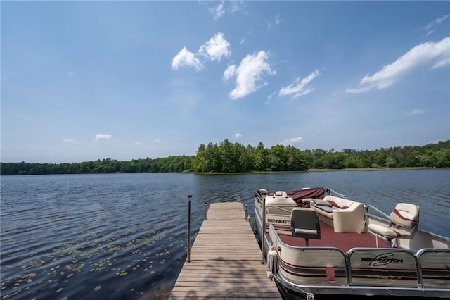dock area featuring a water view and a wooded view