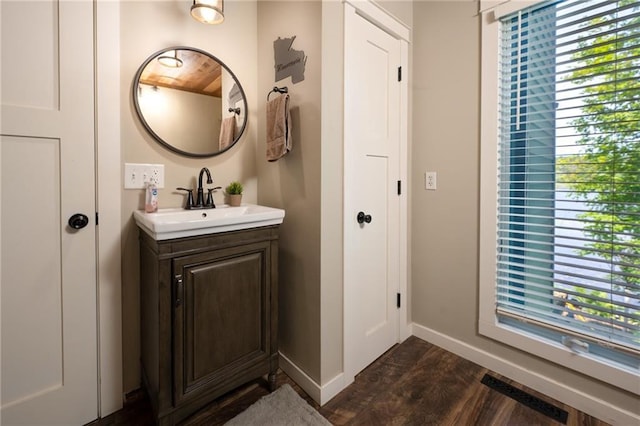 bathroom with vanity, baseboards, and wood finished floors