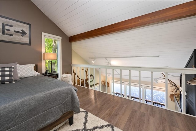 bedroom with vaulted ceiling, wood finished floors, and rail lighting