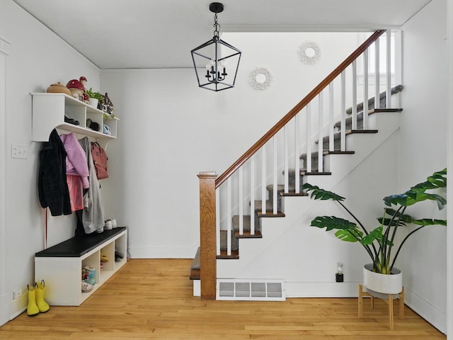 409 Huron St, Manitowoc, WI 54220 - mudroom featuring wood finished floors, a chandelier, and baseboards