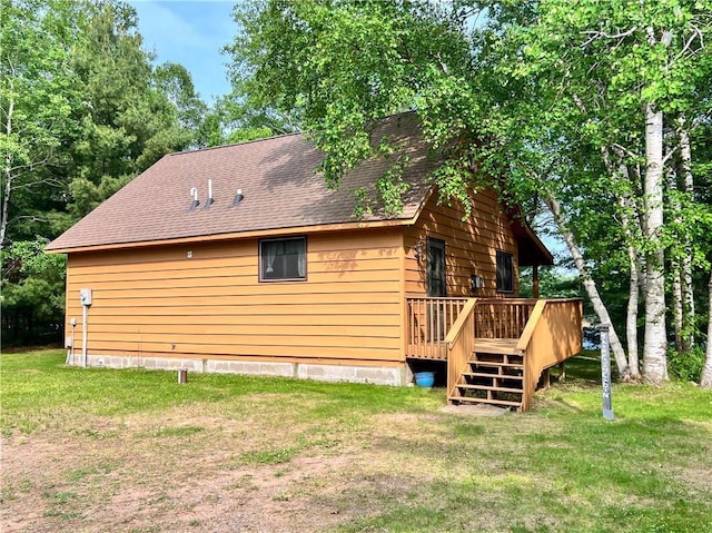 24730 Scenic View Ln, Spooner, WI 54801 - view of side of property with a deck, roof with shingles, and a yard