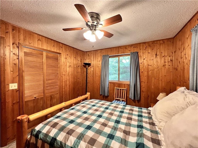 24730 Scenic View Ln, Spooner, WI 54801 - bedroom with a textured ceiling, wood walls, a closet, and a ceiling fan