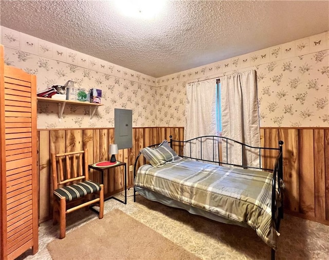 24730 Scenic View Ln, Spooner, WI 54801 - bedroom featuring wainscoting, a textured ceiling, wallpapered walls, electric panel, and carpet floors