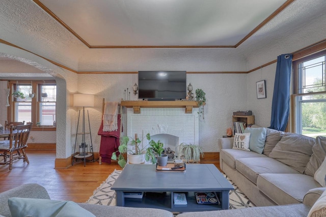2116 N 60th St Unit 2118, Milwaukee, WI 53208 - living area featuring a textured wall, wood finished floors, arched walkways, a fireplace, and baseboards