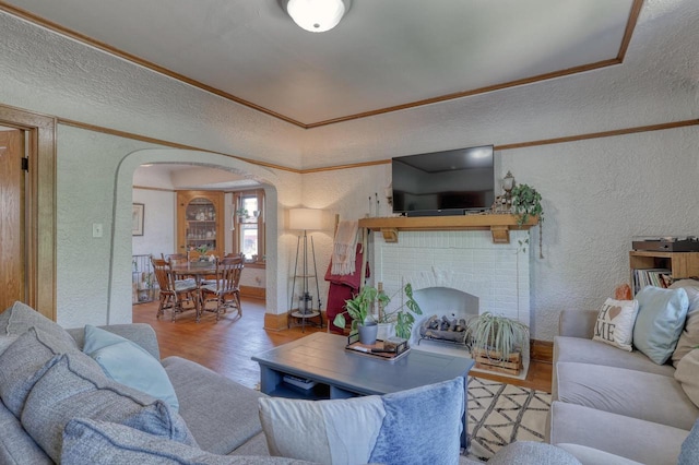 2116 N 60th St Unit 2118, Milwaukee, WI 53208 - living room featuring a textured wall, arched walkways, wood finished floors, baseboards, and a brick fireplace