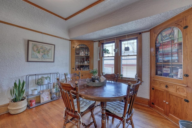 2116 N 60th St Unit 2118, Milwaukee, WI 53208 - dining room with a textured wall, light wood-style floors, crown molding, and baseboards