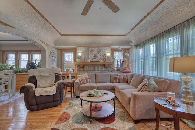 2116 N 60th St Unit 2118, Milwaukee, WI 53208 - living area featuring light wood-style flooring, a tray ceiling, a ceiling fan, arched walkways, and a textured ceiling