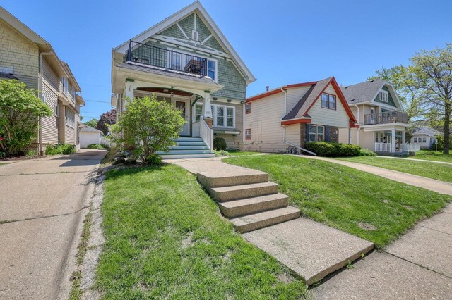 2116 N 60th St Unit 2118, Milwaukee, WI 53208 - view of front of home with a balcony, a front yard, an outdoor structure, and a porch