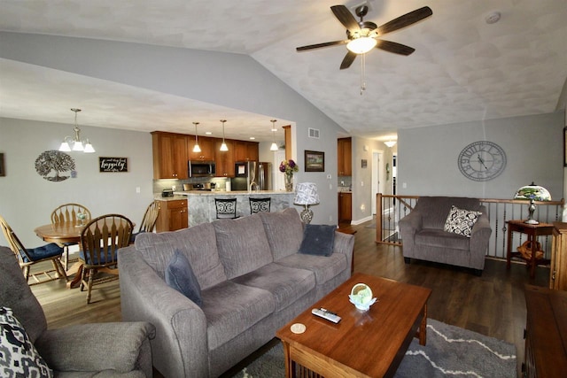 2253 Walnut St, Beloit, WI 53511 - living room with vaulted ceiling, ceiling fan, dark wood-type flooring, a chandelier, and baseboards