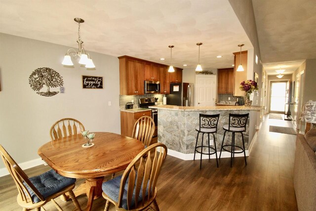 2253 Walnut St, Beloit, WI 53511 - dining space featuring dark wood finished floors, baseboards, a chandelier, and recessed lighting