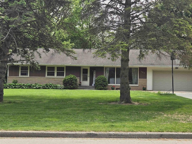 4817 Morgan Dr, Manitowoc, WI 54220 - view of front facade featuring brick siding, an attached garage, a front yard, concrete driveway, and a shingled roof
