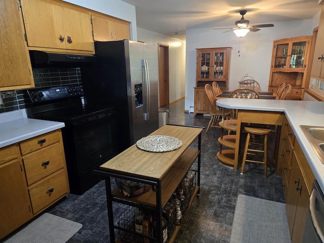 4817 Morgan Dr, Manitowoc, WI 54220 - kitchen with black range with electric cooktop, exhaust hood, decorative backsplash, and light countertops