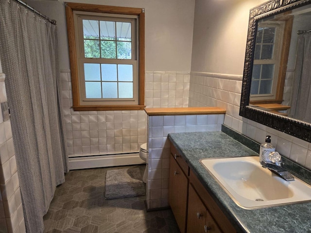 4817 Morgan Dr, Manitowoc, WI 54220 - full bath featuring a baseboard heating unit, tile walls, vanity, toilet, and tile patterned floors