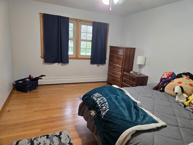 4817 Morgan Dr, Manitowoc, WI 54220 - bedroom featuring wood finished floors, a baseboard heating unit, and baseboards