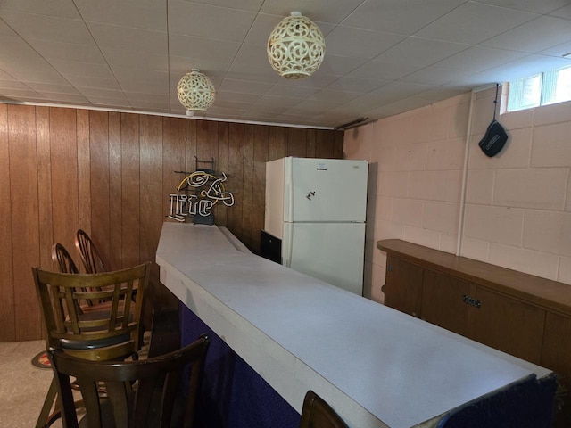 4817 Morgan Dr, Manitowoc, WI 54220 - kitchen featuring freestanding refrigerator and wood walls