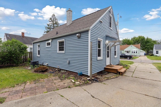 947 Cleveland St, Beloit, WI 53511 - view of side of property with a chimney, cooling unit, and a shingled roof