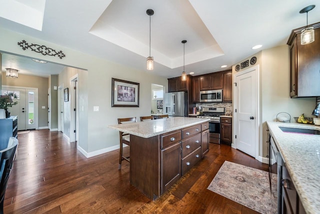 905 W Hubble Ln, Appleton, WI 54913 - kitchen with stainless steel appliances, a sink, a breakfast bar, baseboards, and dark brown cabinetry
