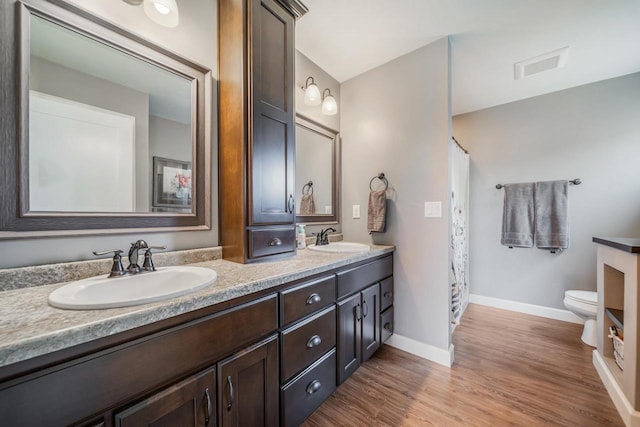 905 W Hubble Ln, Appleton, WI 54913 - bathroom featuring toilet, double vanity, baseboards, wood finished floors, and curtained shower