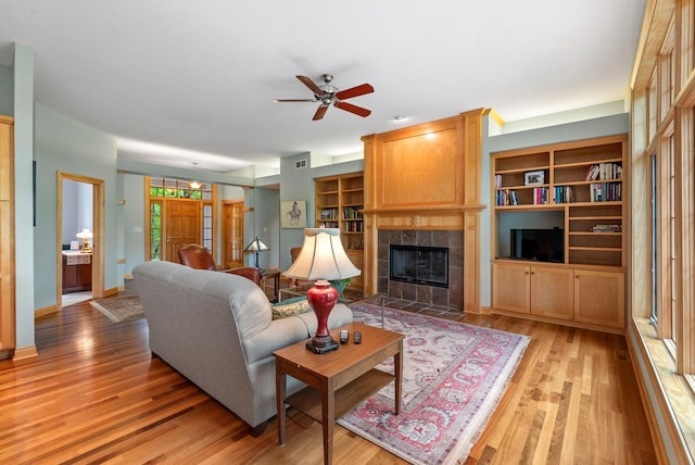 W3847 Timber Lake Rd, East Troy, WI 53120 - living room featuring light wood finished floors, a tile fireplace, ceiling fan, and baseboards