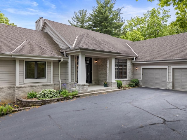 W3847 Timber Lake Rd, East Troy, WI 53120 - single story home featuring an attached garage, brick siding, driveway, a shingled roof, and a chimney