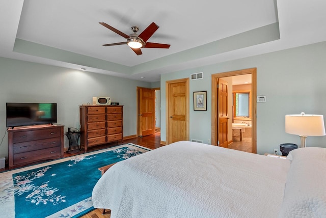 W3847 Timber Lake Rd, East Troy, WI 53120 - bedroom featuring a raised ceiling, wood finished floors, baseboards, ensuite bath, and ceiling fan