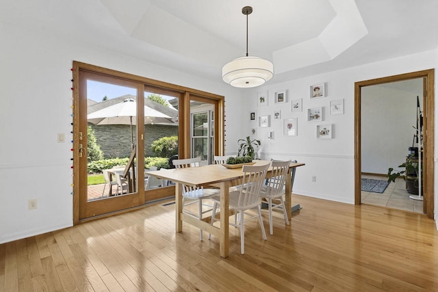 1323 Bradford Ct, Neenah, WI 54956 - dining area with light wood-style floors, a raised ceiling, and baseboards