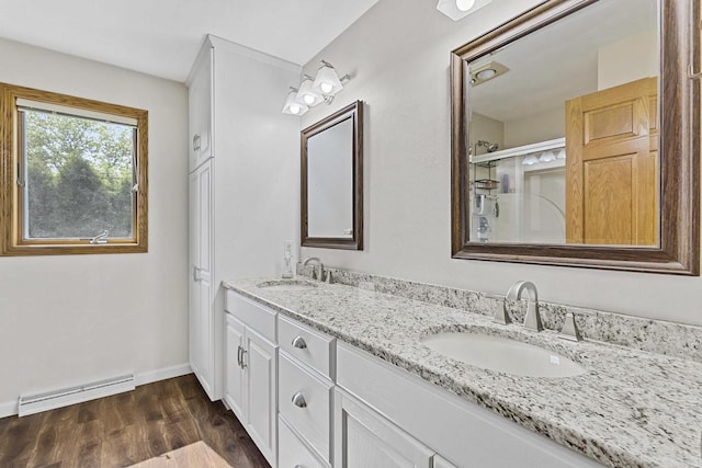 1323 Bradford Ct, Neenah, WI 54956 - bathroom with a baseboard heating unit, double vanity, wood finished floors, and baseboards