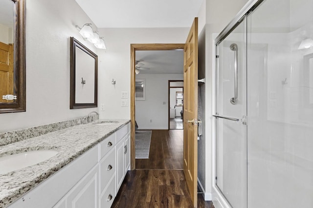 1323 Bradford Ct, Neenah, WI 54956 - full bath with wood finished floors, double vanity, a stall shower, a ceiling fan, and baseboards