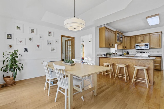 1323 Bradford Ct, Neenah, WI 54956 - dining space with a raised ceiling, light wood-style floors, and baseboards