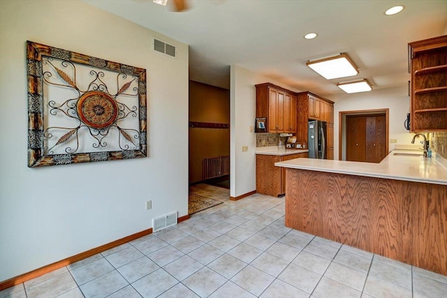 2040 Continental Ln, Cross Plains, WI 53528 - kitchen featuring radiator, open shelves, freestanding refrigerator, backsplash, and light tile patterned floors