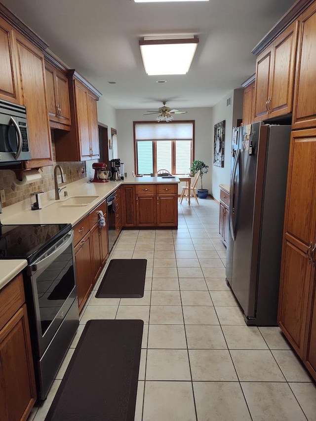 2040 Continental Ln, Cross Plains, WI 53528 - kitchen with stainless steel appliances, brown cabinets, and light tile patterned floors