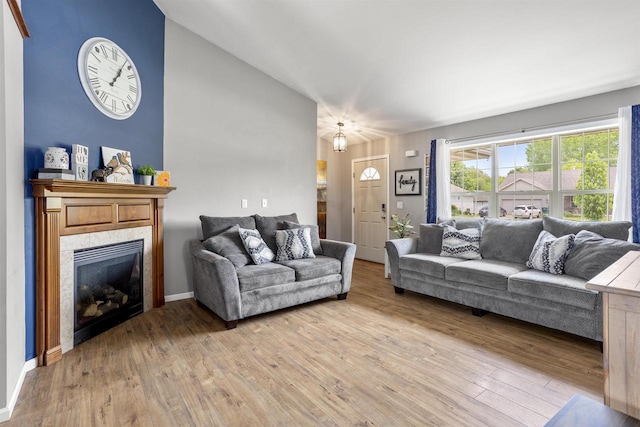 763 Severndroog Way, Howard, WI 54313 - living area featuring light wood-style flooring, a fireplace, baseboards, and vaulted ceiling