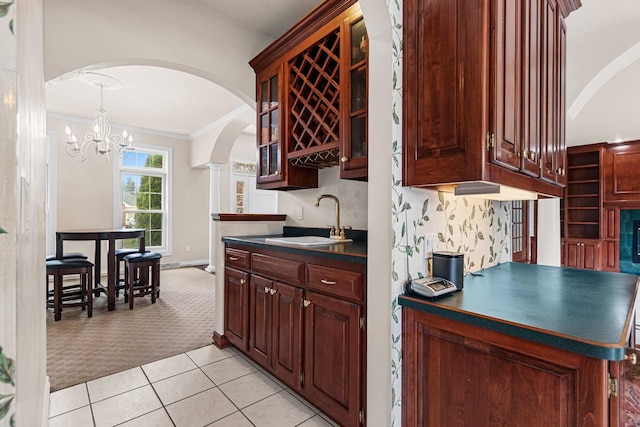 139 Sullivan Ln, De Pere, WI 54115 - kitchen featuring a sink, dark countertops, light colored carpet, arched walkways, and ornamental molding