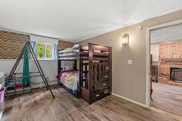 1123 S Park Ave, Neenah, WI 54956 - bedroom featuring wood finished floors, baseboards, crown molding, a brick fireplace, and a baseboard radiator