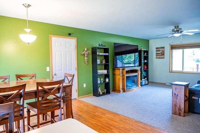 2371 Doris Rd, Reedsburg, WI 53959 - dining space with ceiling fan, a fireplace, baseboards, wood finished floors, and carpet