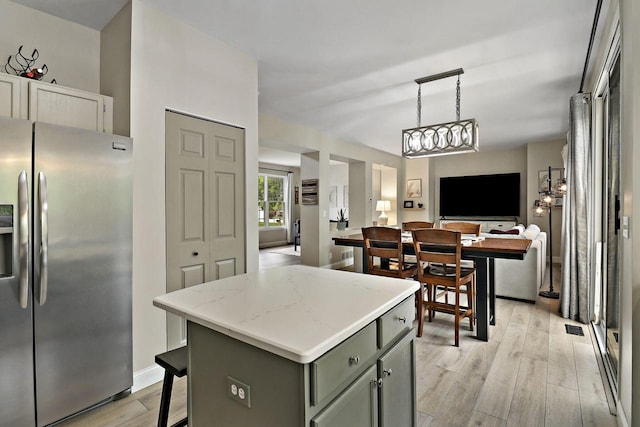 20506 83rd Pl, Bristol, WI 53104 - kitchen with stainless steel fridge with ice dispenser, open floor plan, light wood-style flooring, a center island, and gray cabinetry