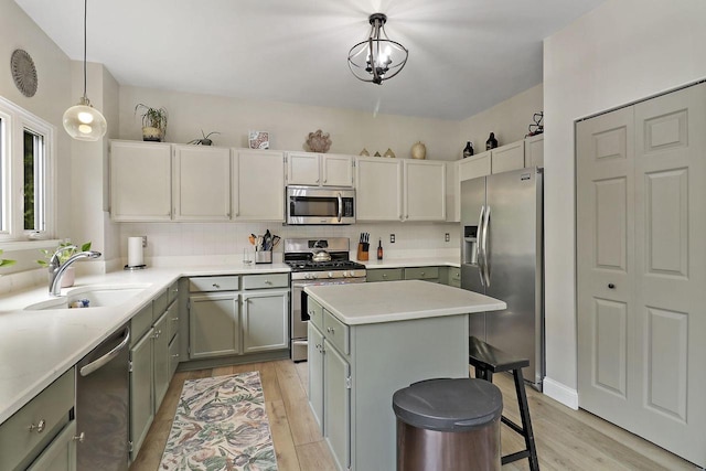 20506 83rd Pl, Bristol, WI 53104 - kitchen with appliances with stainless steel finishes, a sink, light wood-style flooring, gray cabinets, and a kitchen island