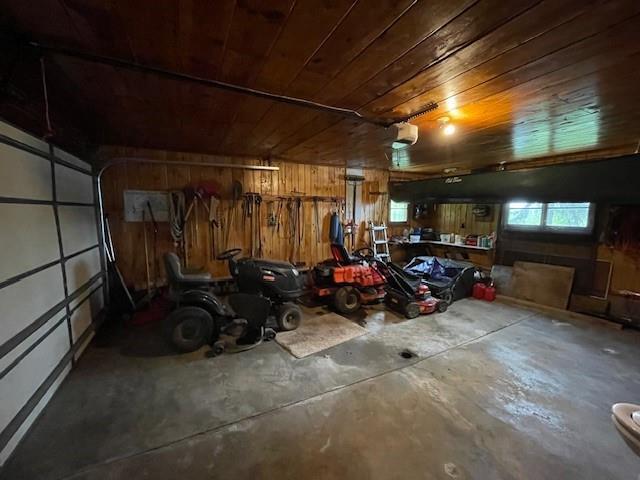 11176 W Plover Ln, Hayward, WI 54843 - garage with wood ceiling, wood walls, and a garage door opener