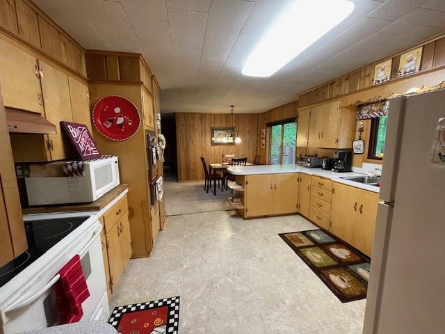 11176 W Plover Ln, Hayward, WI 54843 - kitchen featuring white appliances, under cabinet range hood, light countertops, wooden walls, and light floors