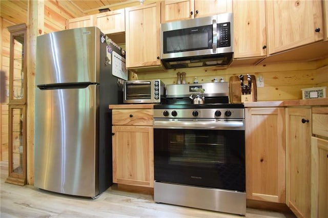 3542 Treasure Island Ter, Danbury, WI 54830 - kitchen with stainless steel appliances, light brown cabinets, light wood finished floors, and wooden walls