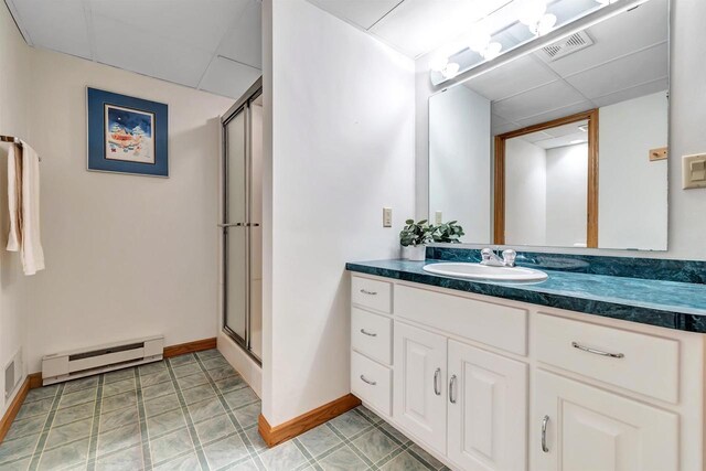 4514 Mohawk Ct, Green Bay, WI 54313 - bathroom featuring a baseboard radiator, vanity, a stall shower, baseboards, and a paneled ceiling