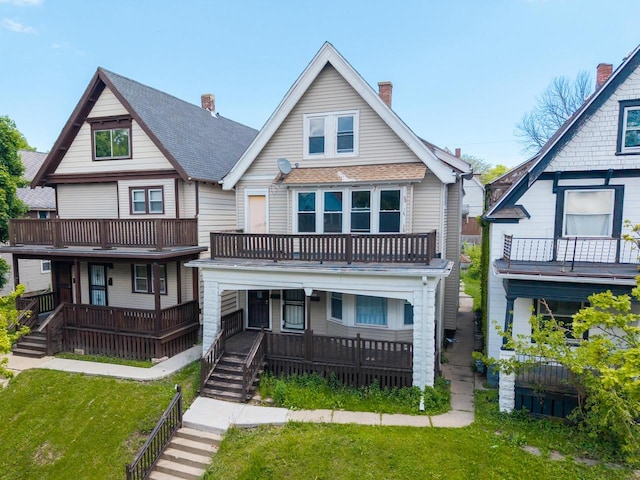 2162 N 41st St Unit 2164, Milwaukee, WI 53208 - view of front facade with a balcony, a chimney, a front yard, and covered porch