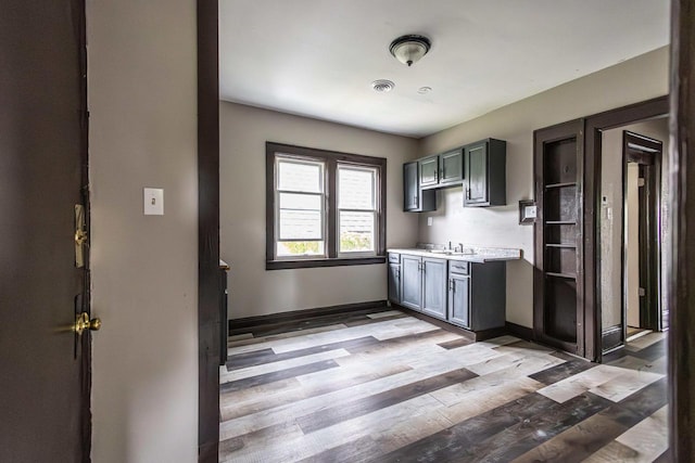 2162 N 41st St Unit 2164, Milwaukee, WI 53208 - kitchen with light countertops, a sink, baseboards, and wood finished floors