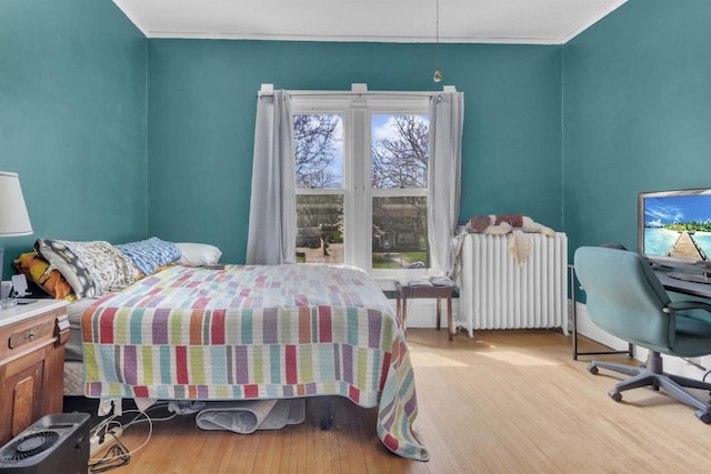 1616 7th St, Menomonie, MI 49858 - bedroom with radiator heating unit, light wood-type flooring, and ornamental molding