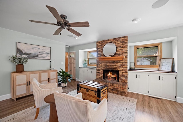 4062 S 106th St, Greenfield, WI 53228 - living room featuring light wood-style floors, a ceiling fan, and a fireplace
