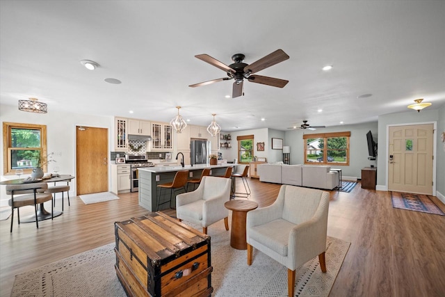 4062 S 106th St, Greenfield, WI 53228 - living area with light wood finished floors, ceiling fan, recessed lighting, and baseboards