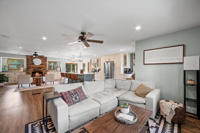 4062 S 106th St, Greenfield, WI 53228 - living area featuring a ceiling fan, a brick fireplace, wood finished floors, recessed lighting, and a chandelier