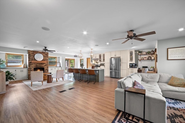 4062 S 106th St, Greenfield, WI 53228 - living room with ceiling fan, healthy amount of natural light, a fireplace, light wood finished floors, and recessed lighting